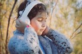 Child listens to headphones outside