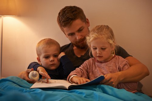 Dad reading with son and daughter