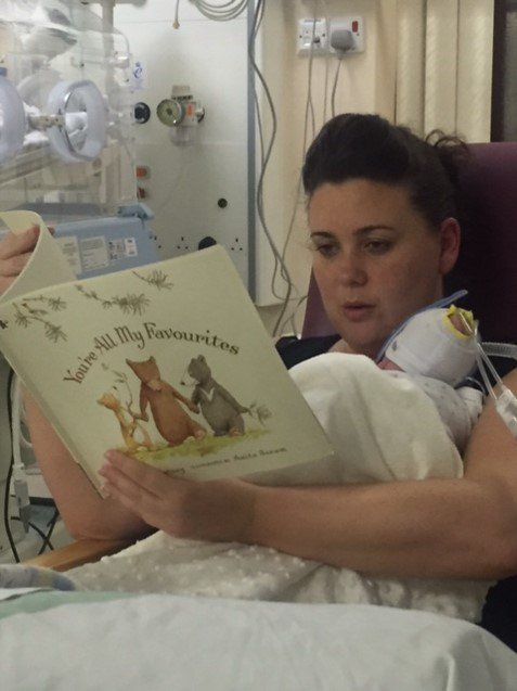Mother reading to premature baby