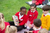 Primary children reading outdoors