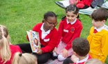 Primary children reading outdoors