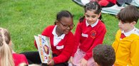 Primary children reading outdoors