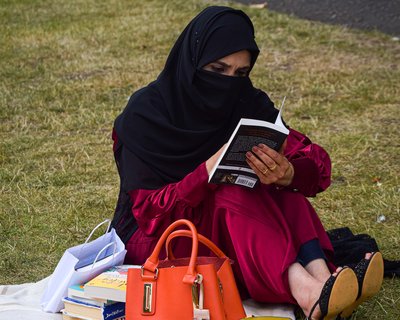 Adult literacy - woman reads a book in the park