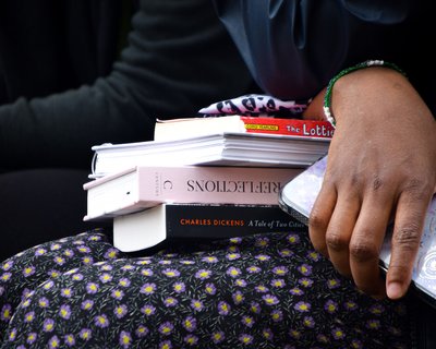 Pile of books on a woman's lap