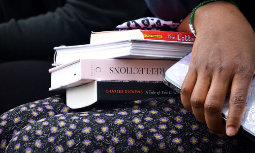 Pile of books on a woman's lap