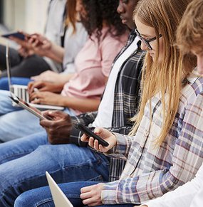 Teenagers looking at tablets and mobile phones