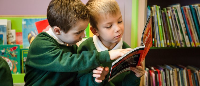 Primary boys share a book