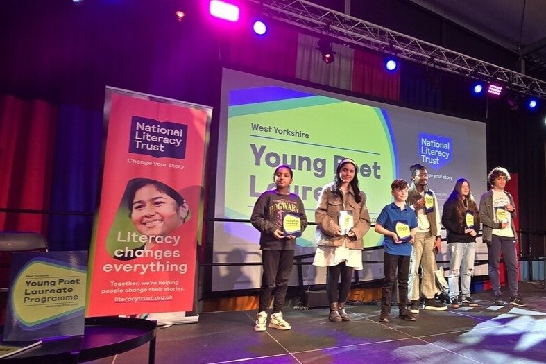 Young poets on stage with awards