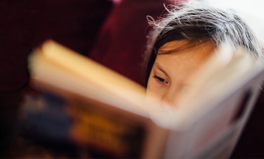 Close up of a young child reading a book