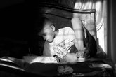 Boy reads a book on his bed - greyscale - reading for pleasure