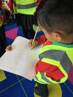 One child dressed up as an engineer taking part in a literacy activity.