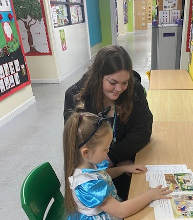 Ellie reads with a student at a primary school in Blackpool