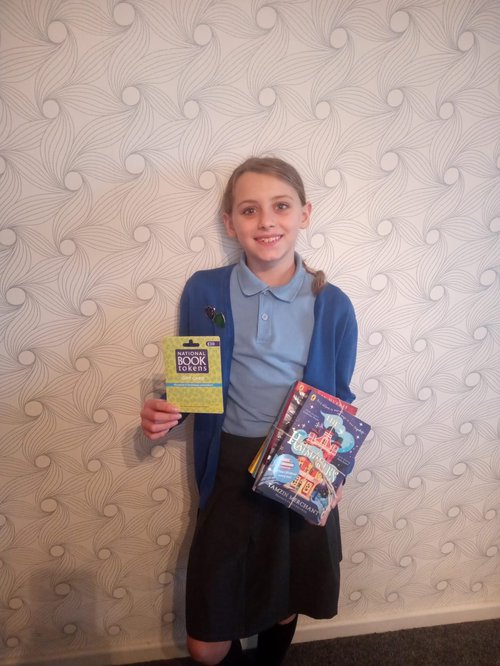 Jessica Hodgson, holding her prize of books and a voucher